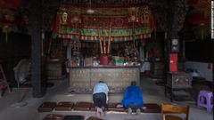 台風の到達前に寺院で祈りをささげる人たち＝１５日、中国