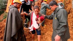 土砂崩れの発生を受けて避難する親子＝フィリピン・ベンゲット州
