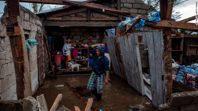 破損した住宅の調べる一家＝１５日、フィリピン/Jes Aznar/Getty Images