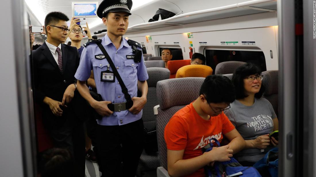 開通初日に車内をパトロールする警官＝２３日/TYRONE SIU/AFP/AFP/Getty Images