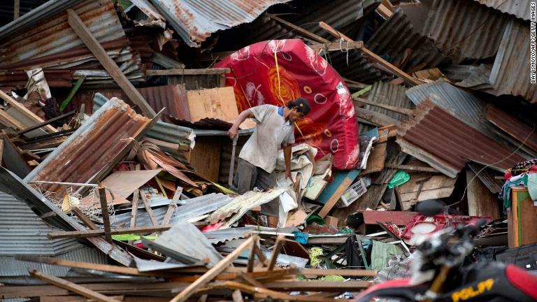倒壊した建物の中で持ち物を探す男性＝２９日/Bay Ismoyo/AFP/Getty Images