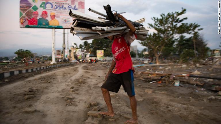 津波に襲われた海岸で物を集める男性＝２９日/Bay Ismoyo/AFP/Getty Images