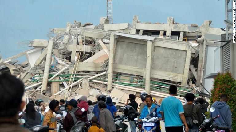 地震で倒壊した建物の周りに集まった住人ら＝２９日、パル市/Muhammad Rifki/AFP/Getty Images