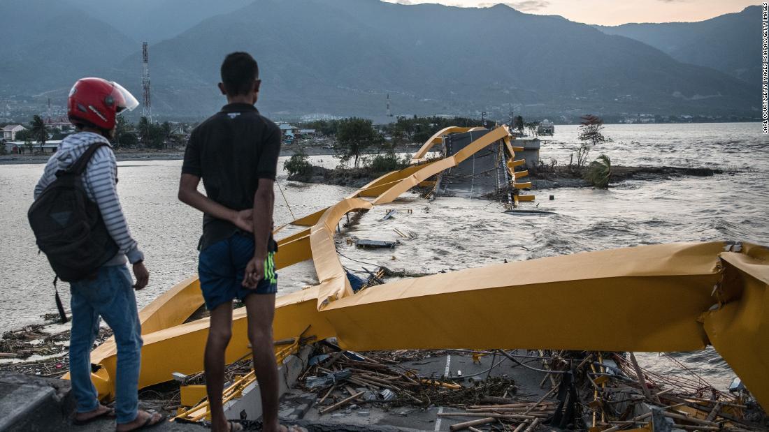 地震や津波によって壊れた橋を見る男性ら/Carl Court/Getty Images AsiaPac/Getty Images