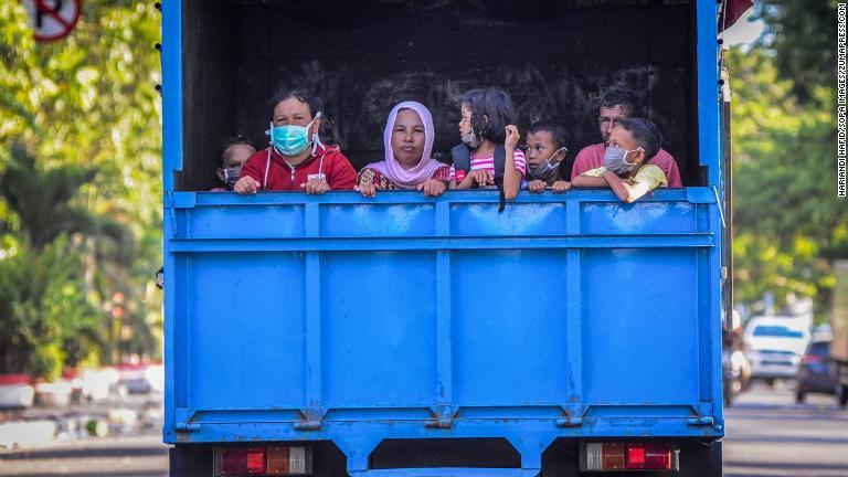 トラックに乗って避難する人々＝３日、インドネシア・パル市/Hariandi Hafid/SOPA Images/ZUMAPRESS.com