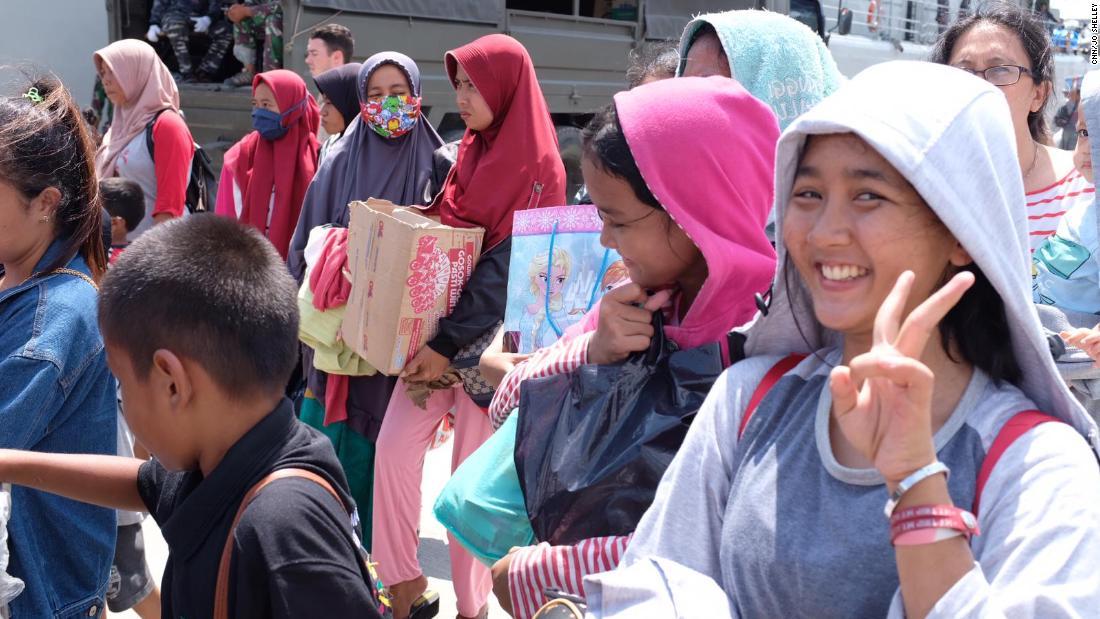 避難のためにインドネシア軍艦艇に乗り込む前に笑顔を見せる女性＝４日/CNN/Jo Shelley