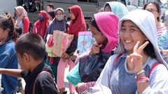 避難のためにインドネシア軍艦艇に乗り込む前に笑顔を見せる女性＝４日