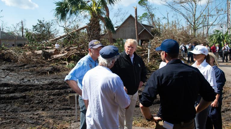 現地当局者から説明を受けるトランプ大統領夫妻＝１５日、フロリダ州/Saul Loeb/AFP/Getty Images