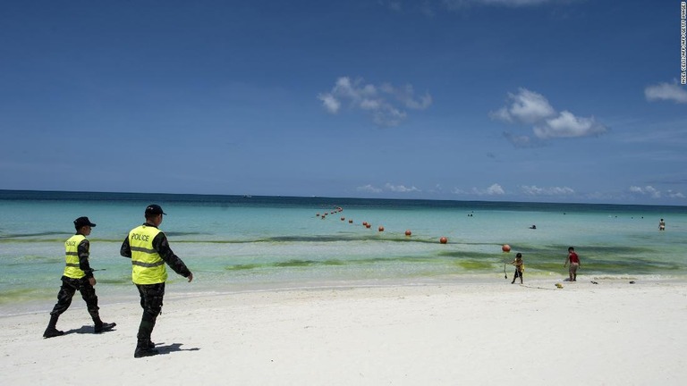 閉鎖直後にビーチを見回る警官/NOEL CELIS/AFP/AFP/Getty Images