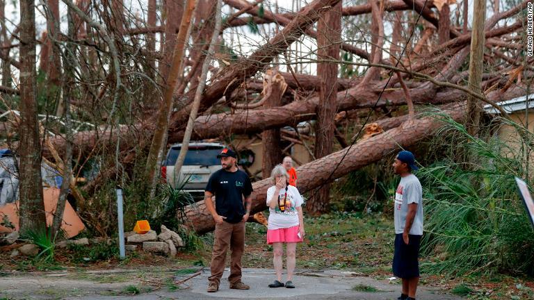 被災した自宅の前に立つ住人=11日、フロリダ州パナマシティー/Gerald Herbert/AP