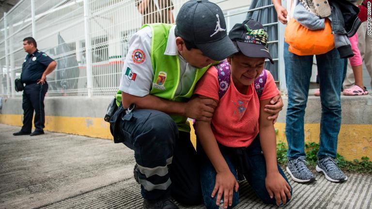 母親が気を失った子どもをなぐさめるメキシコの係官/Oliver de Ros/AP
