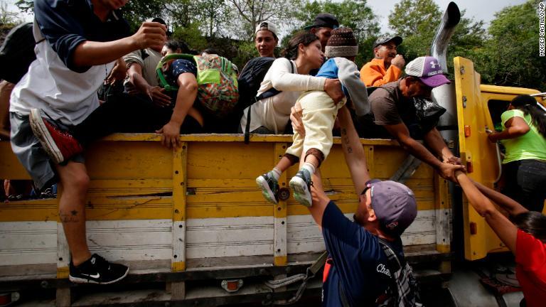 トラックの荷台に乗り込む移民ら＝１７日/Moises Castillo/AP