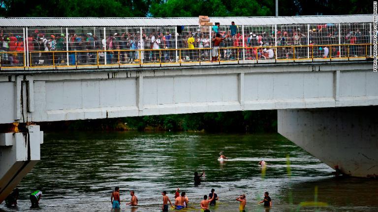 グアテマラとメキシコを結ぶ橋には多くの移民が。一部は川を渡った＝２０日/Pedro Pardo/AFP/Getty Images
