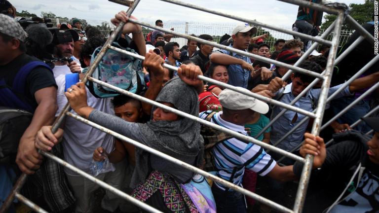 グアテマラ・メキシコ国境の柵を排除しようとする移民ら＝１９日/Pedro Pardo/Getty Images