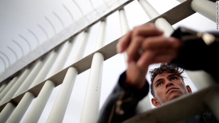 ゲートから先を見つめる男性＝２０日/Ueslei Marcelino/REUTERS