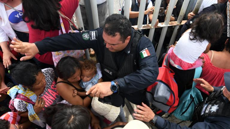 グアテマラとの国境で移民の親子を守るメキシコの係官＝１９日/Orlando Sierra/Getty Images
