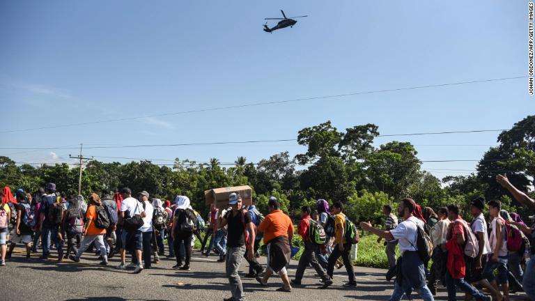 集団の上空を飛ぶメキシコ連邦警察のヘリコプター/Johan Ordonez/AFP/Getty Images