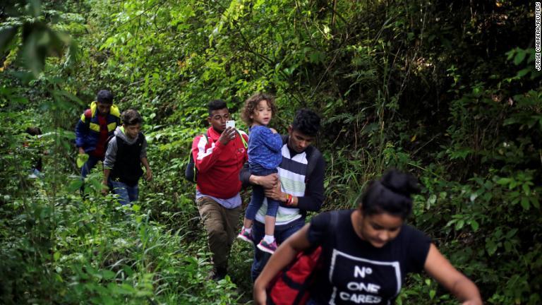 ホンジュラスとグアテマラの国境近くの森を移動する移民ら/Jorge Cabrera/Reuters