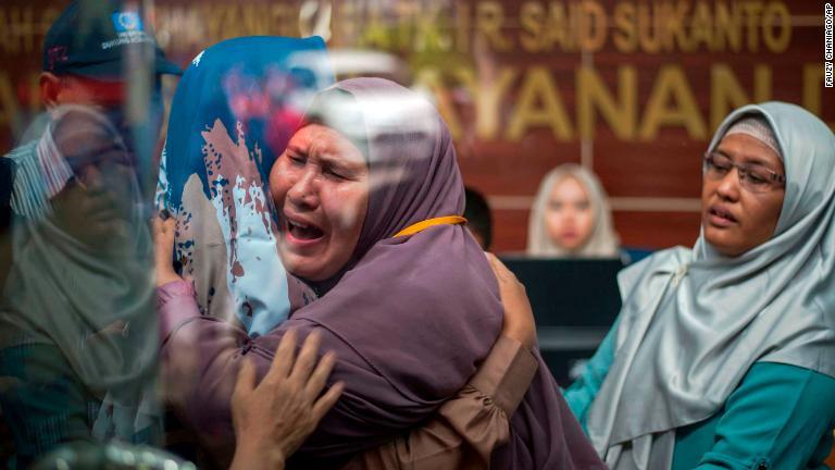 ジャカルタの病院で抱き合う犠牲者の関係者/Fauzy Chaniago/AP