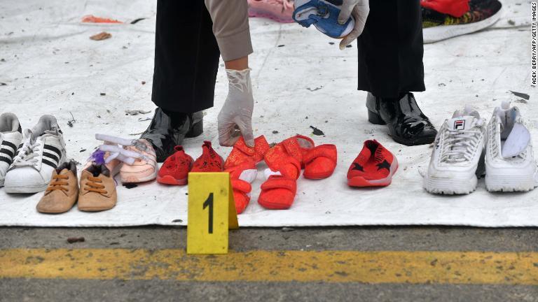 回収された履物を並べる警官/Adek BerryP/AFP/Getty Images