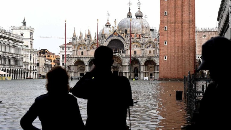 冠水したサンマルコ広場の写真を撮る観光客＝１０月２９日/Miguel Medina/AFP/Getty Images