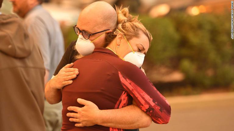 病院の駐車場で抱き合う人たち＝８日、カリフォルニア州パラダイス/Josh Edelson/AFP/Getty Images