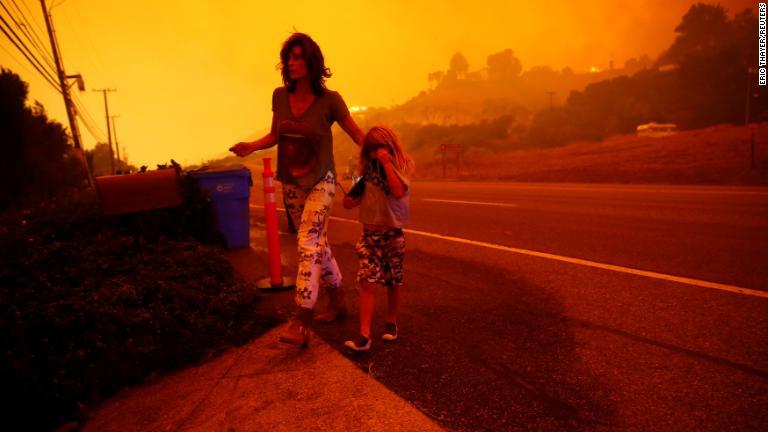 自宅に火事が迫り避難する親子＝９日/Eric Thayer/Reuters
