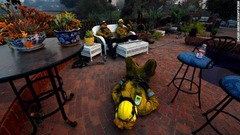 住宅の裏庭で休憩をとる徹夜明けの消防隊員＝９日、ウェストレイクビレッジ