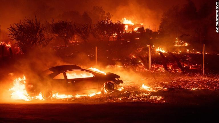 山火事に巻き込まれて燃える車両＝８日、カリフォルニア州パラダイス/Josh Edelson/Getty Images