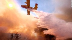 上空から水をまく航空機＝１２日、カリフォルニア州シミバレー
