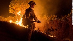 消火作業にあたる消防隊員＝１４日、カリフォルニア州オーロビル