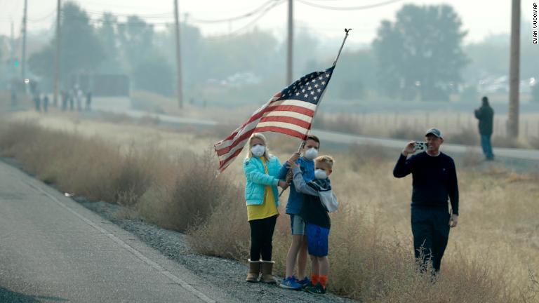 トランプ大統領の車両が通過する際に星条旗を振る子どもたち＝１７日、カリフォルニア州/Evan Vucci/AP