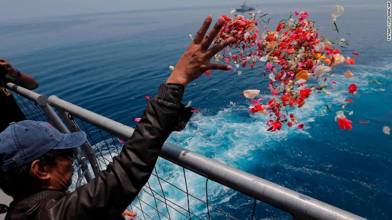 インドネシア軍の艦船の上から花びらをまく遺族＝６日/Tatan Syuflana/AP