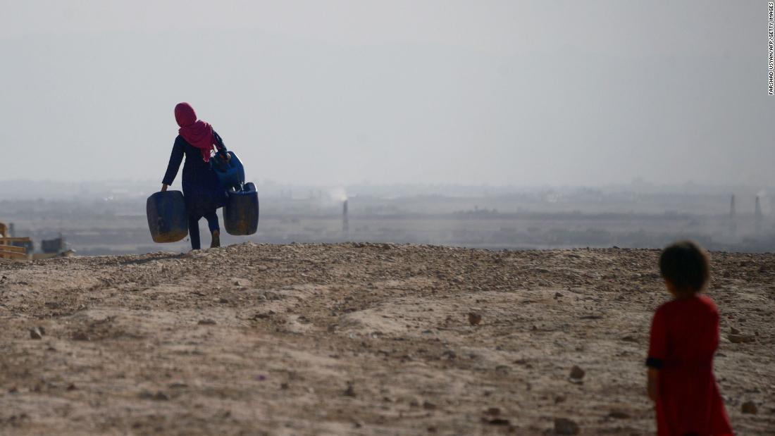 水をくみに空の容器を運ぶ少女＝７月１９日、アフガン北部マザーリシャリフ郊外のサキ村/FARSHAD USYAN/AFP/Getty Images