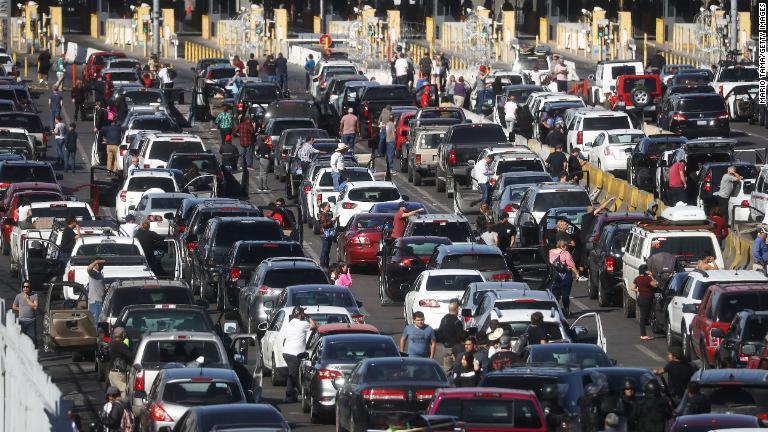 国境閉鎖のため立ち往生している米国へ向かおうとする人々の車両/Mario Tama/Getty Images
