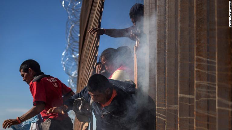催涙ガスが使われたことを受けて、メキシコ側に戻る移民/Adrees Larif/REUTERS