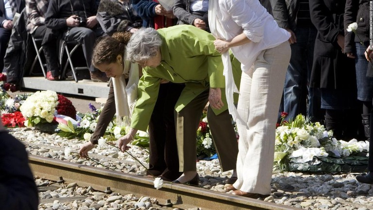 ホロコーストを逃れたオランダ人生存者が孫とともにベステルボルク収容所解放６５年の記念の花をささげる＝２０１０年/MARCEL ANTONISSE/AFP/Getty Images