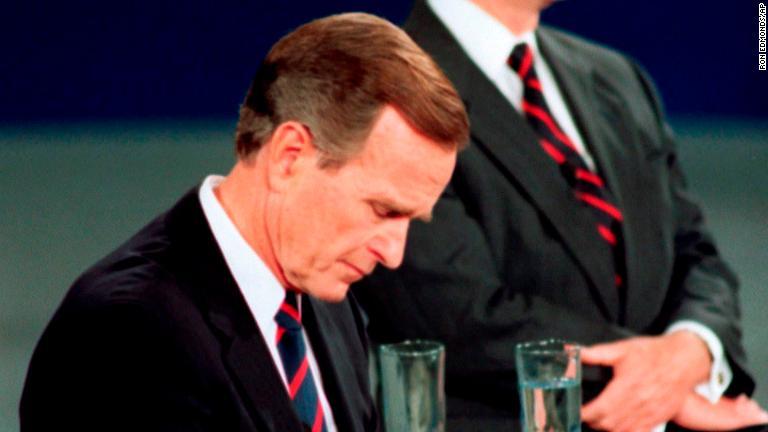 １９９２年の大統領選でロス・ペロー、ビル・クリントン両候補との討論会で時計を気にするブッシュ氏。このしぐさが大統領としての資質を疑われる動きだと解釈された/Ron Edmonds/AP