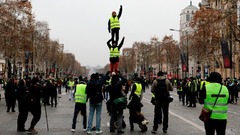 「人間タワー」を作るデモ参加者＝１５日、パリのシャンゼリゼ通り