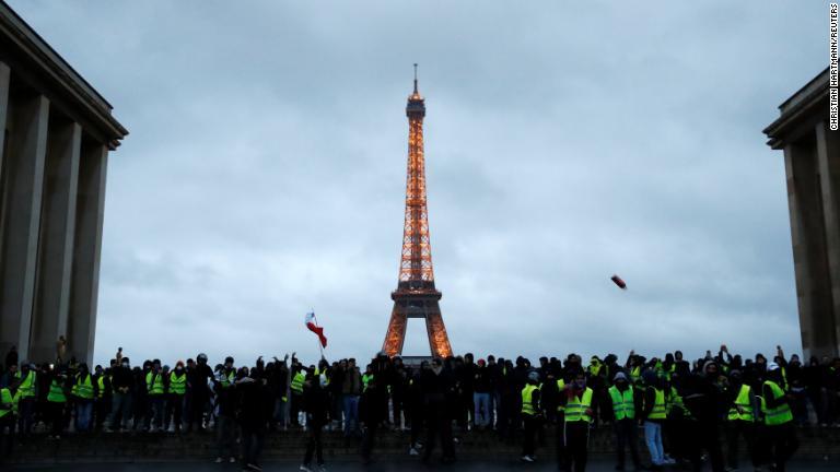 エッフェル塔の前に集まったデモの参加者＝８日/Christian Hartmann/REUTERS