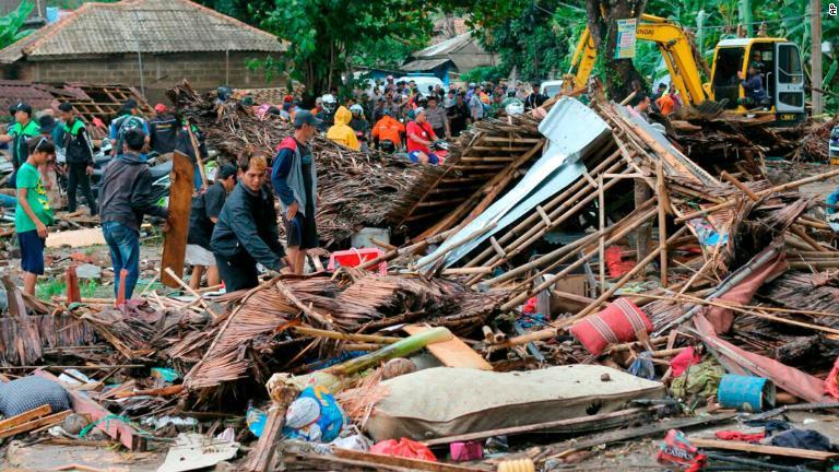 損壊した建物の様子を確認する人たち＝２３日、カリタ/AP