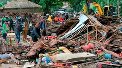 損壊した建物の様子を確認する人たち＝２３日、カリタ
