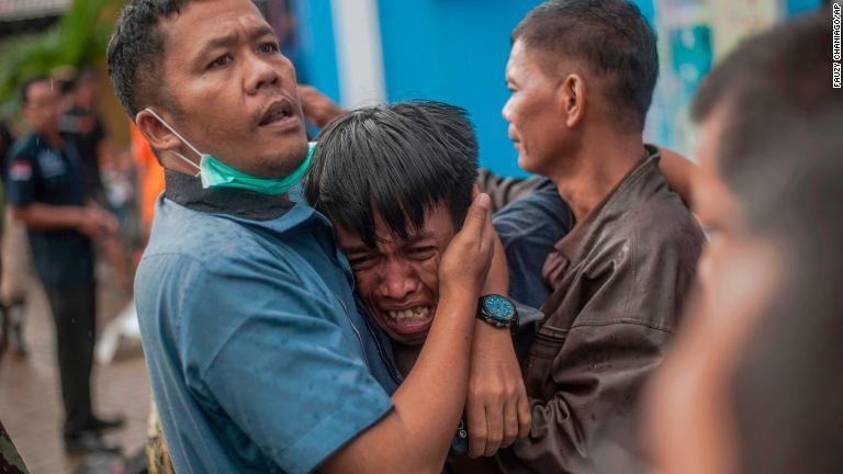 親族の遺体を確認後、涙を流す男性＝２３日、カリタ/Fauzy Chaniago/AP