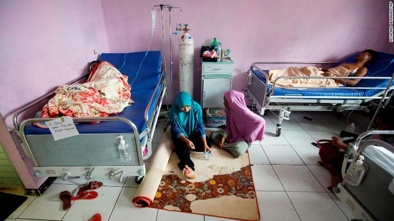 避難先の病院で休息する生存者＝２４日、インドネシア・パンデグラン/Achmad Ibrahim/AP