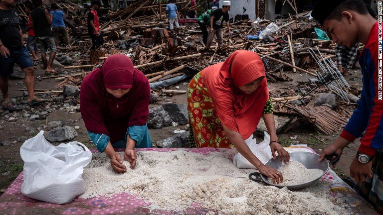 破損した家屋から米を回収する女性たち＝インドネシア・カリタ/Ulet Ifansasti/Getty Images AsiaPac/Getty Images