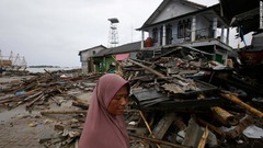 被災地を歩く女性＝２５日