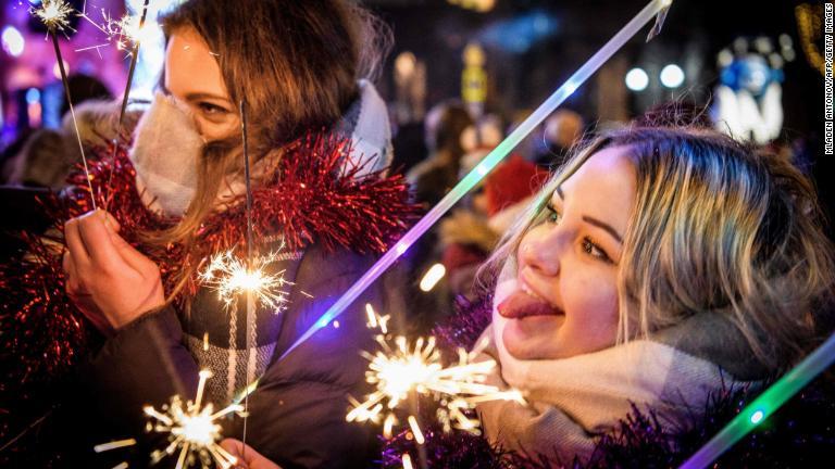 花火で新年を祝う女性＝ロシア・モスクワ/Mladen Antonov/AFP/Getty Images