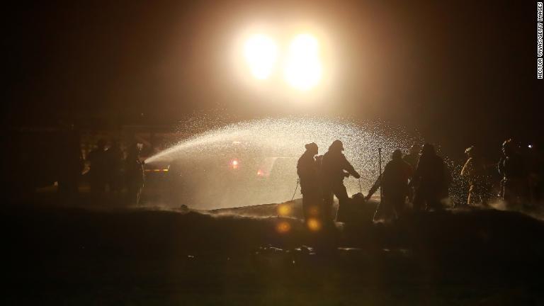 消火活動にあたる消防隊員。爆発の原因について捜査が行われている/Hector Vivas/Getty Images