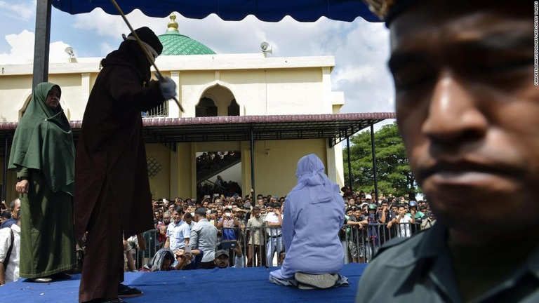 むちうち刑を受ける１８歳の女性/CHAIDEER MAHYUDDIN/AFP/AFP/Getty Images