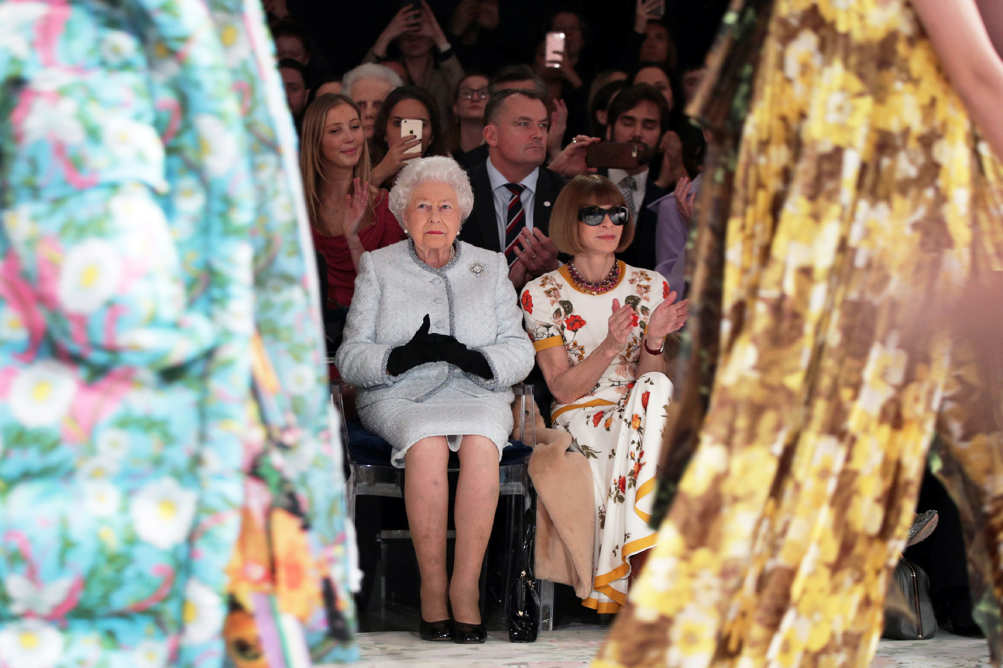 リチャード・クインのランウェイショーに出席したエリザベス女王。ファッション誌「ヴォーグ」の編集者アナ・ウィンターの隣に座っている/YUI MOK/AFP/AFP/Getty Images